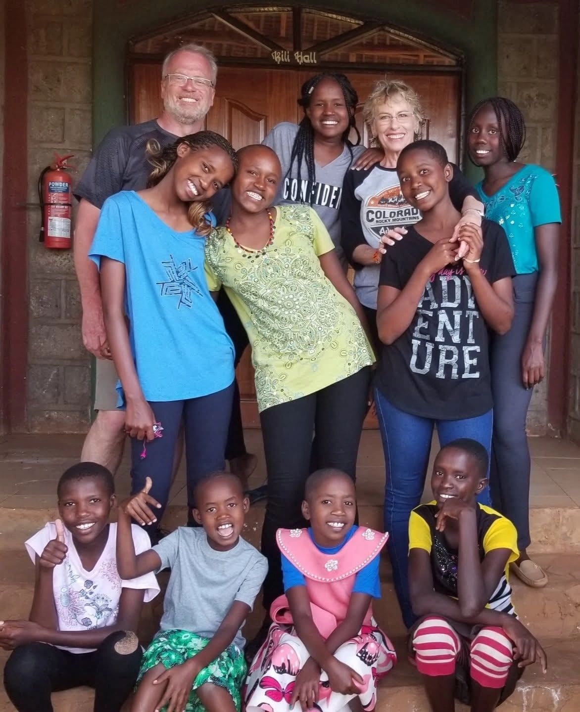 Group of happy children and adults posing together indoors.