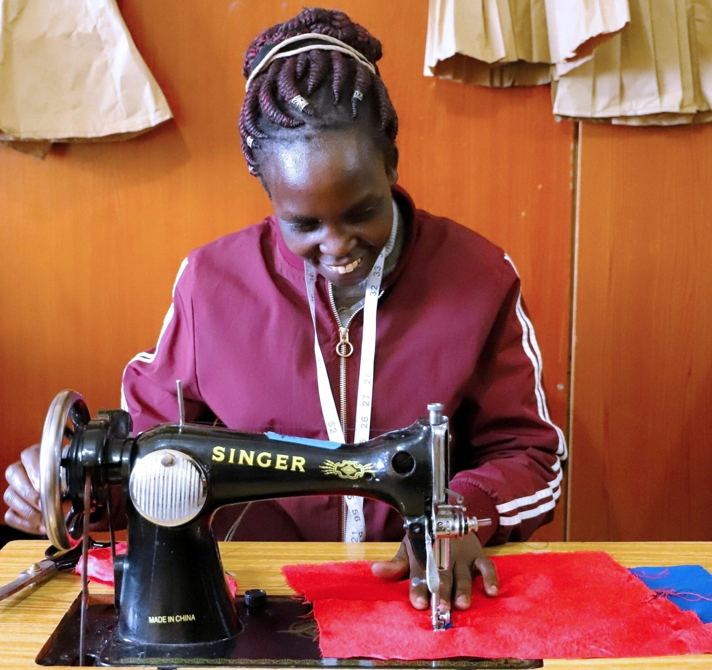 A woman sewing fabric using a vintage Singer sewing machine.
