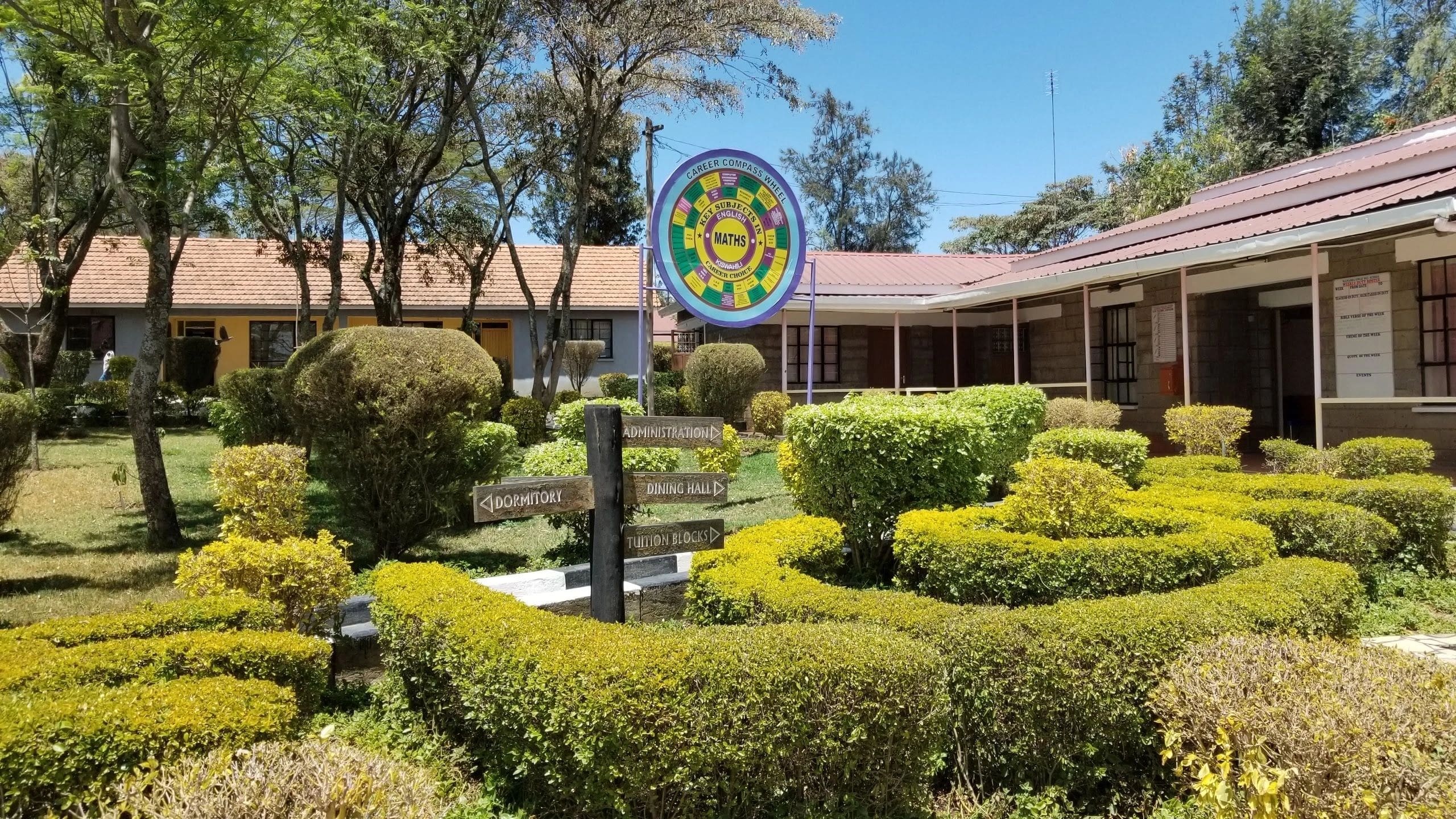 Well-maintained garden with trimmed bushes and a colorful circular emblem.