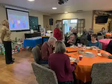 People gathered in a cozy room for a group activity or class.