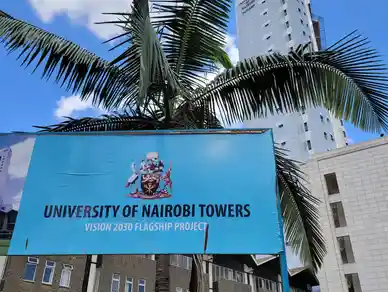 University of Nairobi Towers sign with palm trees and a tall building in the background.
