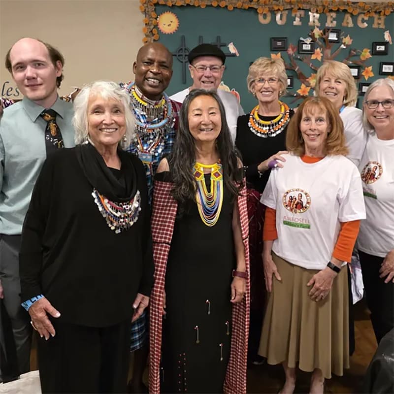 A group of smiling seniors posing together indoors.