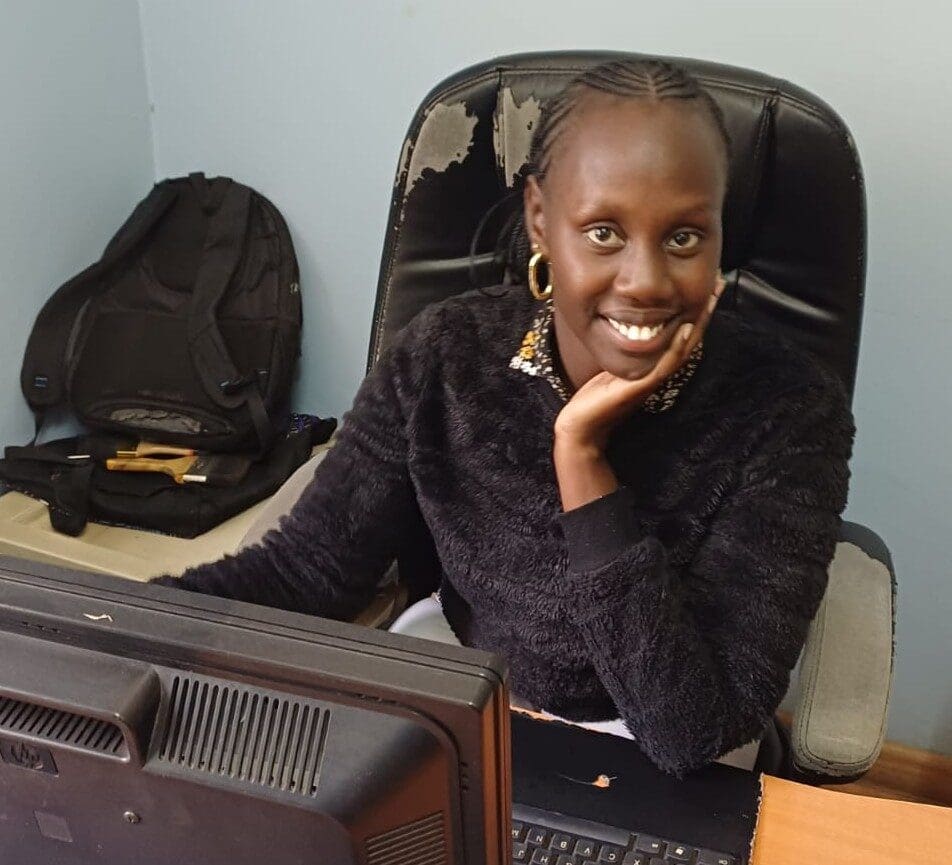 Smiling woman sitting at a desk in an office.