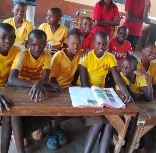 Group of smiling schoolchildren in yellow uniforms
